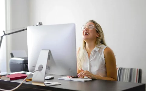 Mulher a sorrir com o computador