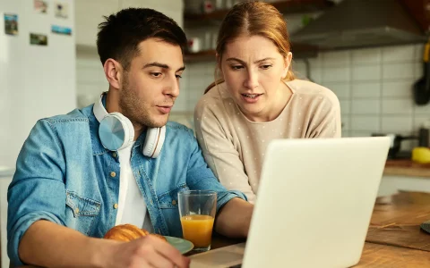 Casal a olhar o computador portátil