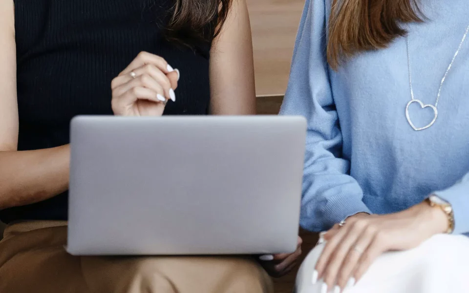 mulheres a segurar o computador portátil
