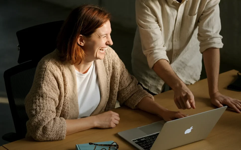 Mulher a sorrir com o computador portátil