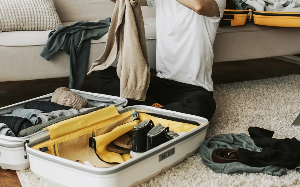 homem a arrumar roupas para viagem