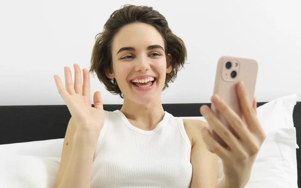 Mulher a sorrir com o telemóvel