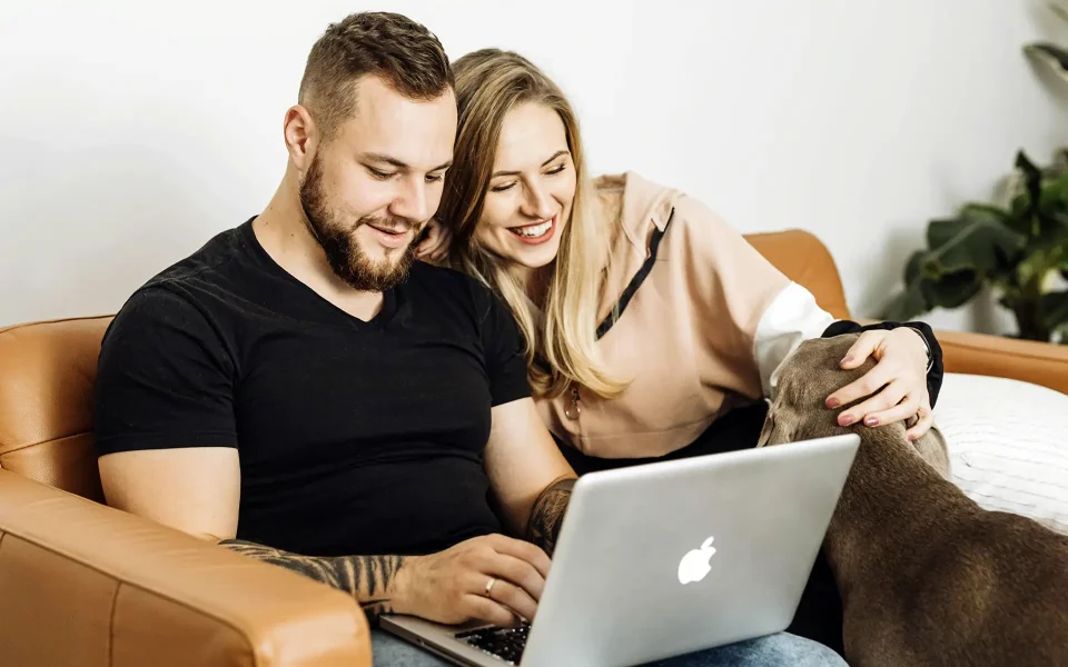 casal no sofá a usar o computador