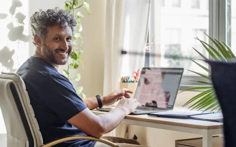 Homem a sorrir no computador