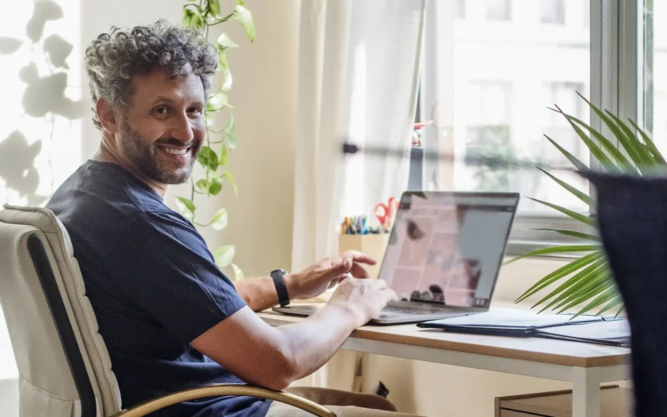 Homem a sorrir no computador