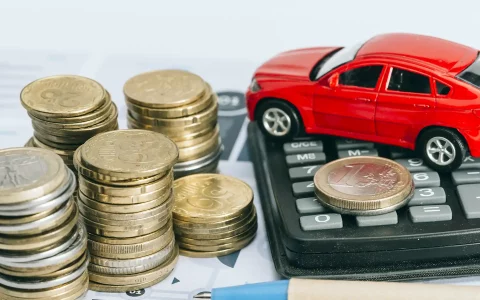 Moedas, calculadora e brinquedo em formato de carro acima da secretaria