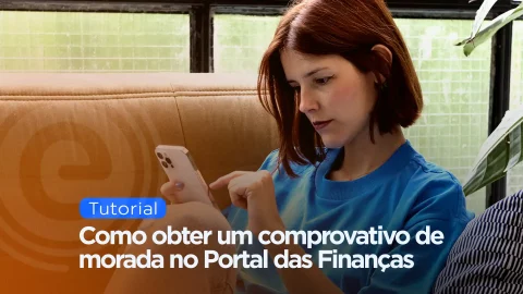 Jovem a utilizar o smartphone com o texto sobreposto 'Tutorial: Como obter um comprovativo de morada no Portal das Finanças