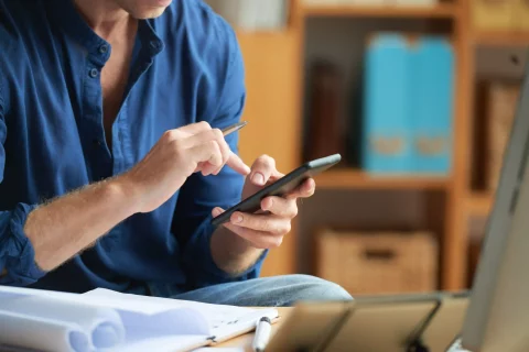 ezgif casually dressed unrecognizable man using smartphone work office Dia Mundial da Poupança